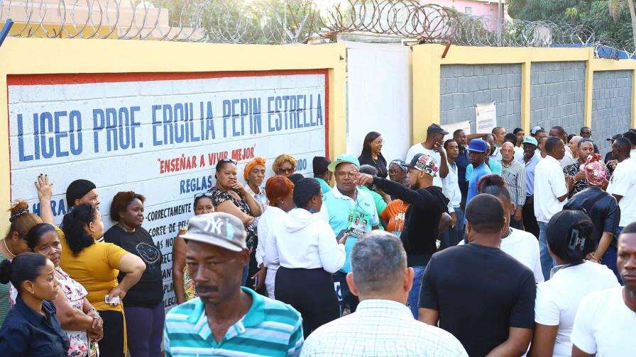 Votantes esperan en largas filas para votar en el Gran Santo Domingo.